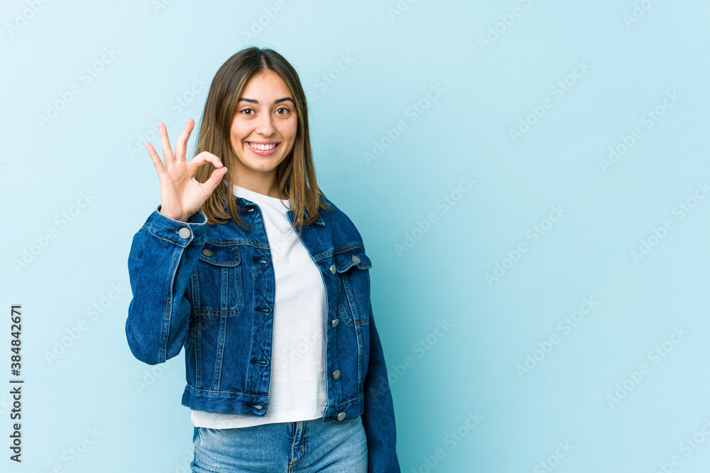 Young caucasian woman cheerful and confident showing ok gesture. Young caucasian woman cheerful and confident showing ok gesture.
