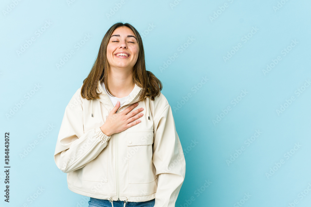 Young caucasian woman laughs out loudly keeping hand on chest. Young caucasian woman laughs out loudly keeping hand on chest.
