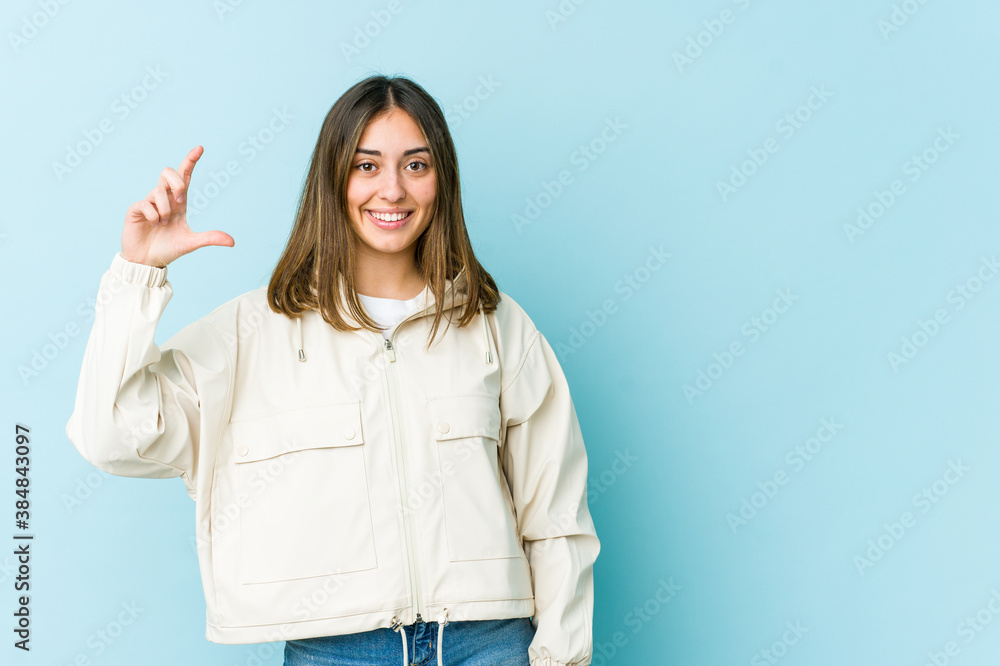Young caucasian woman holding something little with forefingers, smiling and confident. Young caucasian woman holding something little with forefingers, smiling and confident.