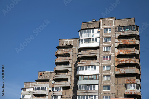 An old multi-storey building of the Soviet era. A rundown, outdated, emergency building against a blue sky.