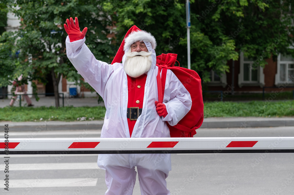 Santa Claus in a protective suit outdoors during the coronavirus epidemic