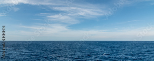 Panorama background sea with small waves and foam and sky with white clouds