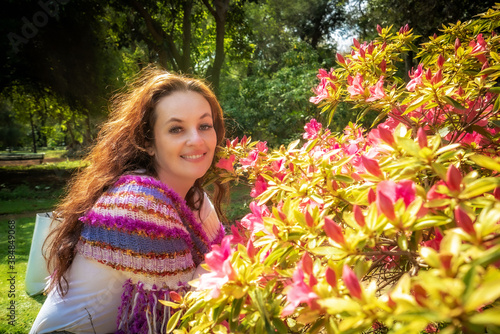portrait of a young woman near flowers in the park