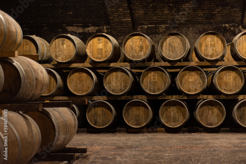 Wooden barrels for wine aging in the cellar. Italian wine.