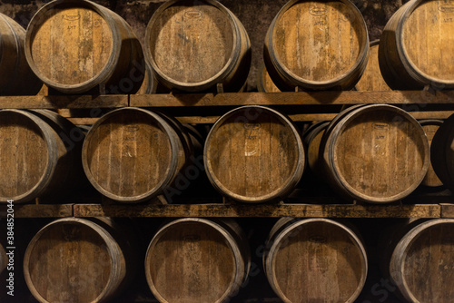 Wooden barrels for wine aging in the cellar. Italian wine. © Stefania