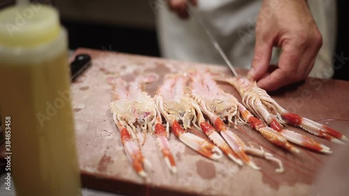 Chef opening some shrimp from Huelva (spain) with a knife to prepare a delicious dinner in a restaurant.