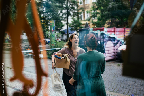 Shop Owner Greeting Friend In The Street