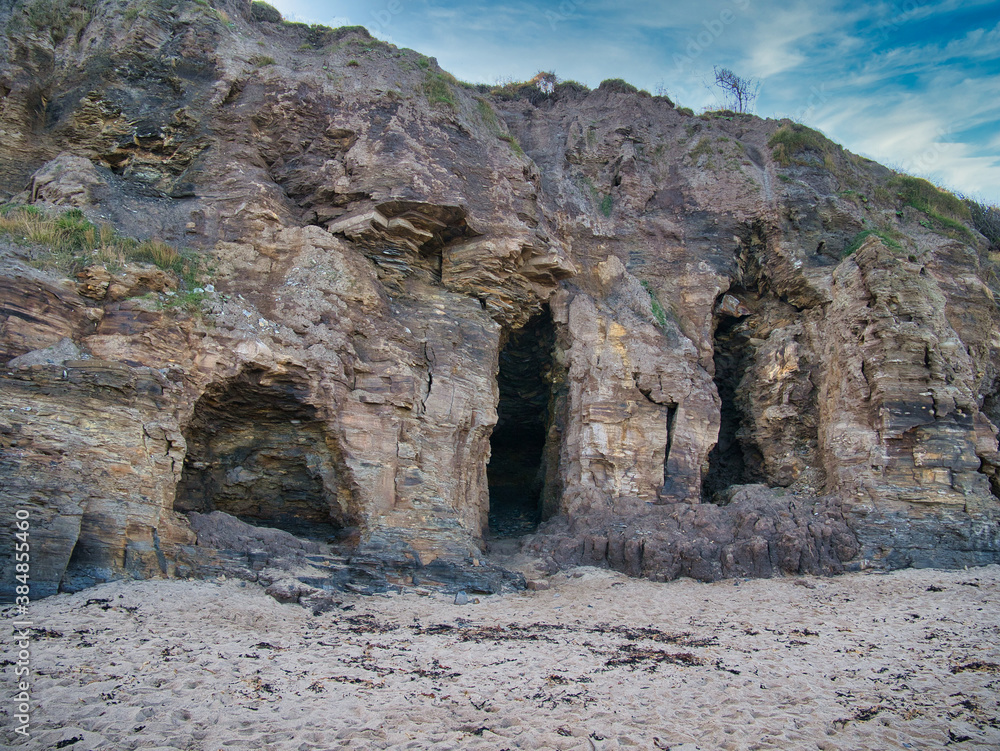 Caves in eroded mudstone cliffs at Runswick Bay in North Yorkshire, UK - part of the Whitby Mudstone Formation - sedimentary bedrock formed in the Jurassic Period