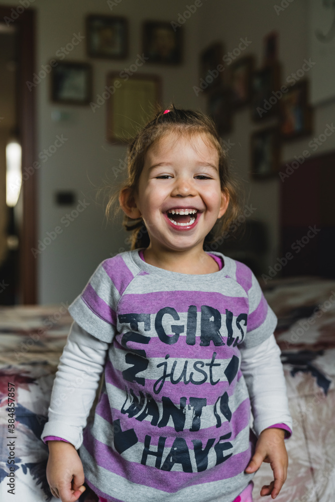 Happy girl laughing near bed