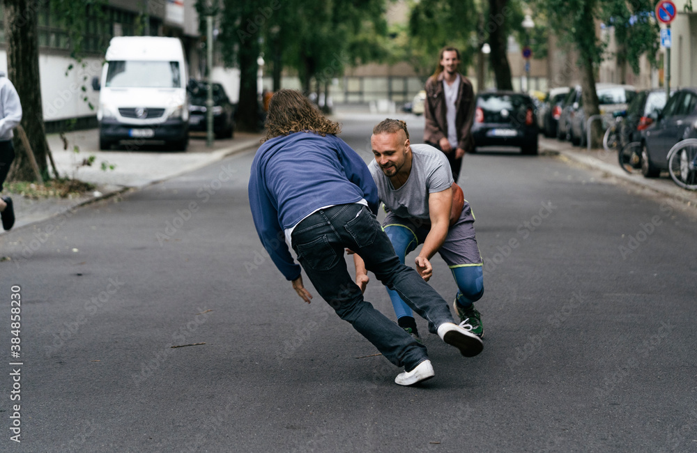 Guys Energetically Playing Stickball In Street Together Guys Energetically Playing Stickball In Street Together