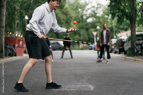 Young Man About To Serve Ball During Game Of Stickball photo