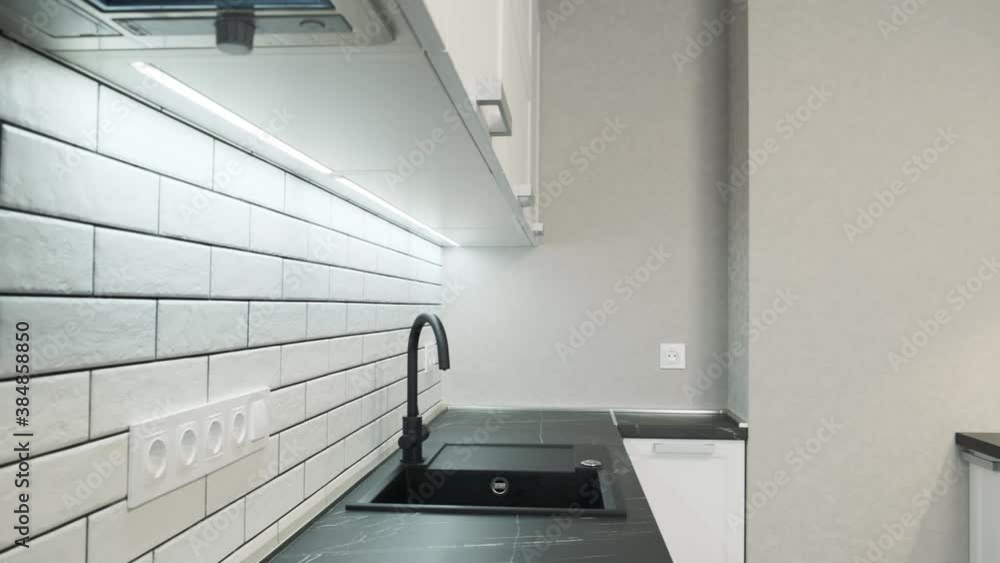 Kitchen sink and faucet. Simple well designed modern white wooden kitchen interior. Ceramic tiles on the wall and wooden countertop. Pan camera move 4k Kitchen sink and faucet. Simple well designed modern white wooden kitchen interior. Ceramic tiles on the wall and wooden countertop. Pan camera move 4k