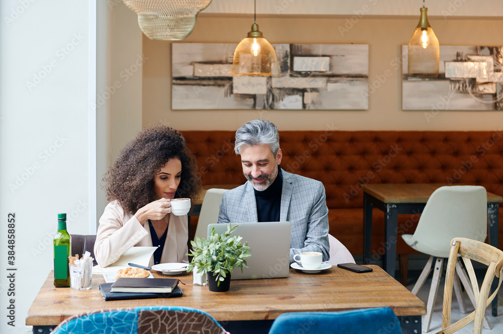 Smiling businesspeople working in a bistro Smiling businesspeople working in a bistro