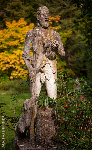 Stone statue of a shepherd with dog in the park