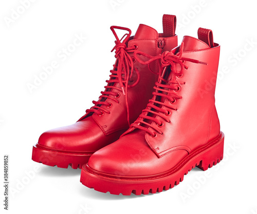 Beautiful pair of high red leather boots on lace and a massive sole with a rough tread, isolated on a white background with a shadow. Trend of the season: brightness and uniqueness of the image.