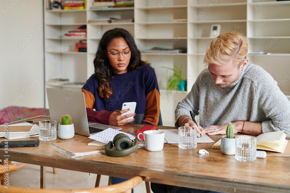 Two people working at a desk Two people working at a desk