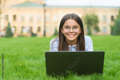 Real happiness. happy girl sitting on green grass with laptop. Start up. child playing computer game. back to school. education online. knowledge day. kid learning private lesson. blogging