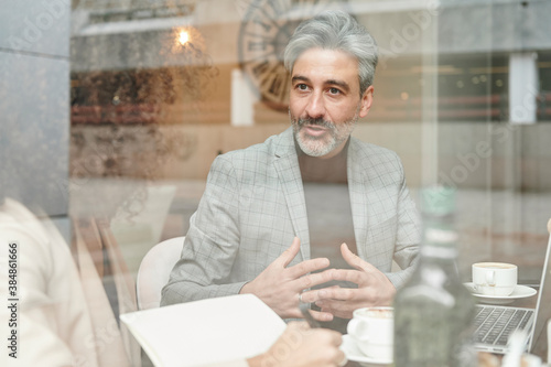 Businessman talking with a colleague in a cafe photo