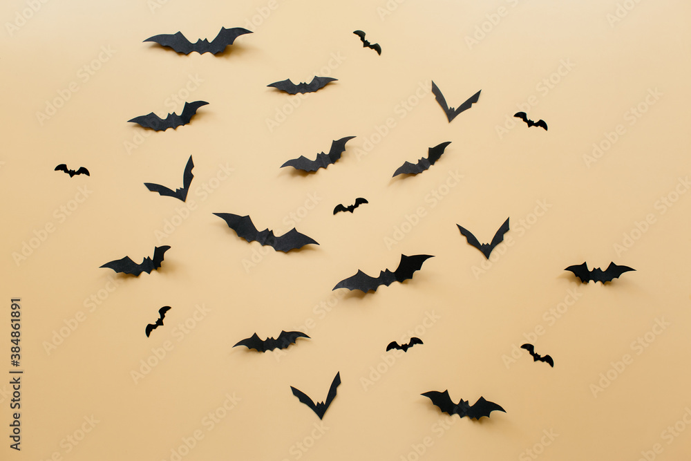 Fototapeta premium Halloween decorations with bats on pastel beige background. Halloween concept. Flat lay, top view, copy space