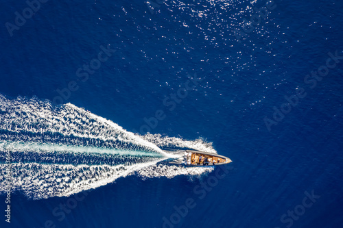 Aerial top down view of a rib motorboat traveling over blue sea  © moofushi