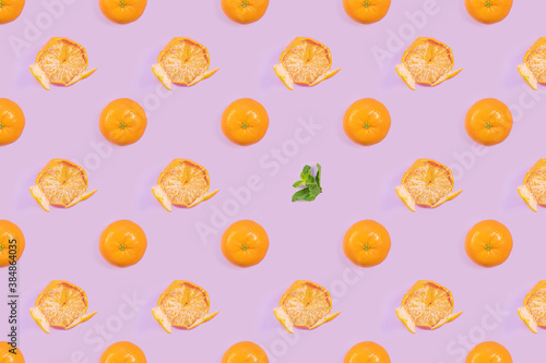 Bright pattern of fresh whole and peeled tangerines, mint on a purple background. Citrus, vitamin C, fruit.
