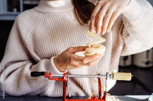 Wall Mural Close up of girl hands slicing and peeling apple using apple peeler corer slicer machine