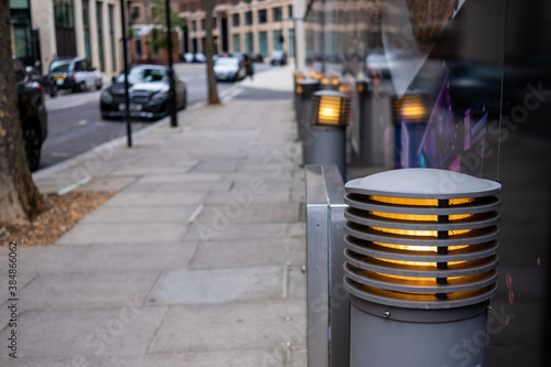 Foto Grey street bollard and lighting with blurred background street scene