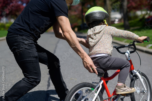 Dad teaching child to ride a bike