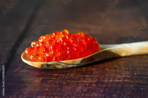 Red caviar in a wooden spoon close-up.