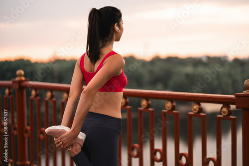Female athlete warming up before jogging in a city