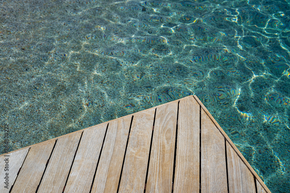 Top view of wood platform or terrace jetty beside the blue crystal clear water background