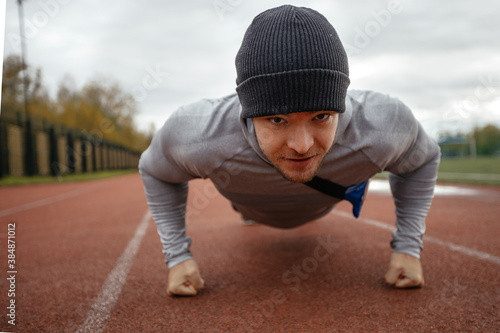 Bottom view is made by an adult Caucasian male . an athlete at the stadium training does push-UPS on a summer day-the concept of a healthy lifestyle of real people .close up © Кирилл Горшков