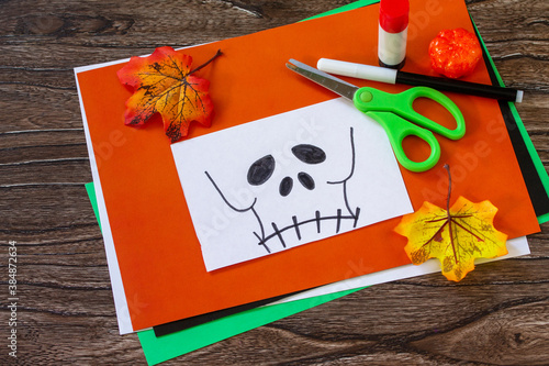 Instruction step 1. Child creates Halloween decor, paper lanterns garland skull for Halloween. Childrens art project, crafts, fun activities for kids.