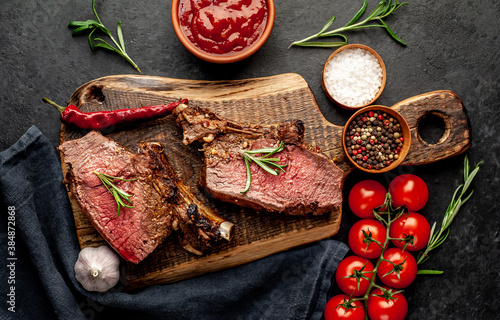 Baked beef on the bone with spices on a stone background