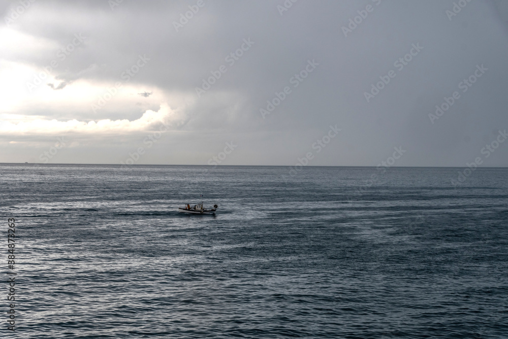Bateau de pêche en mer avec un ciel nuageux
