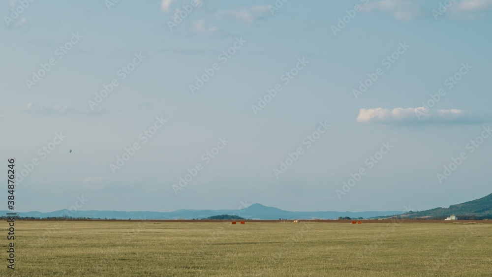 Family stands next to airfield on the countryside under beautiful weather