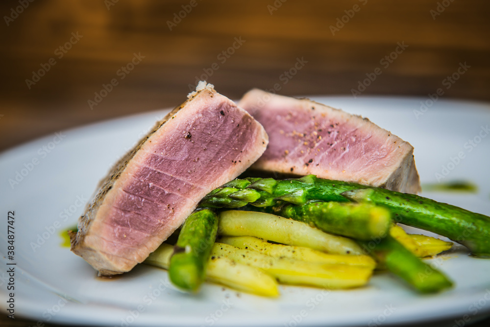 Tuna steak with asparagus and bean pods. The food in the restaurant. Food styling and restaurant meal serving. Tuna steak with asparagus and bean pods. The food in the restaurant. Food styling and restaurant meal serving.