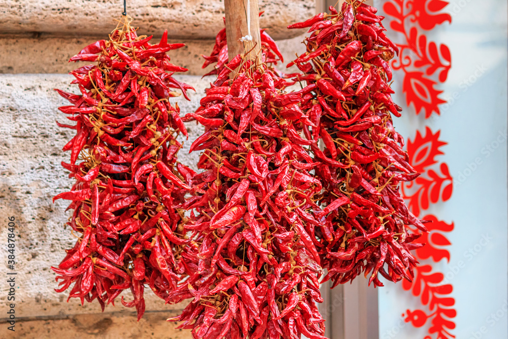View close-up on garlands of dried red peppers hung on the counter of street spice shop in downtown Budapest, Hungary