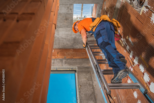 Contractor on a Ladder Inside Newly Constructed Building