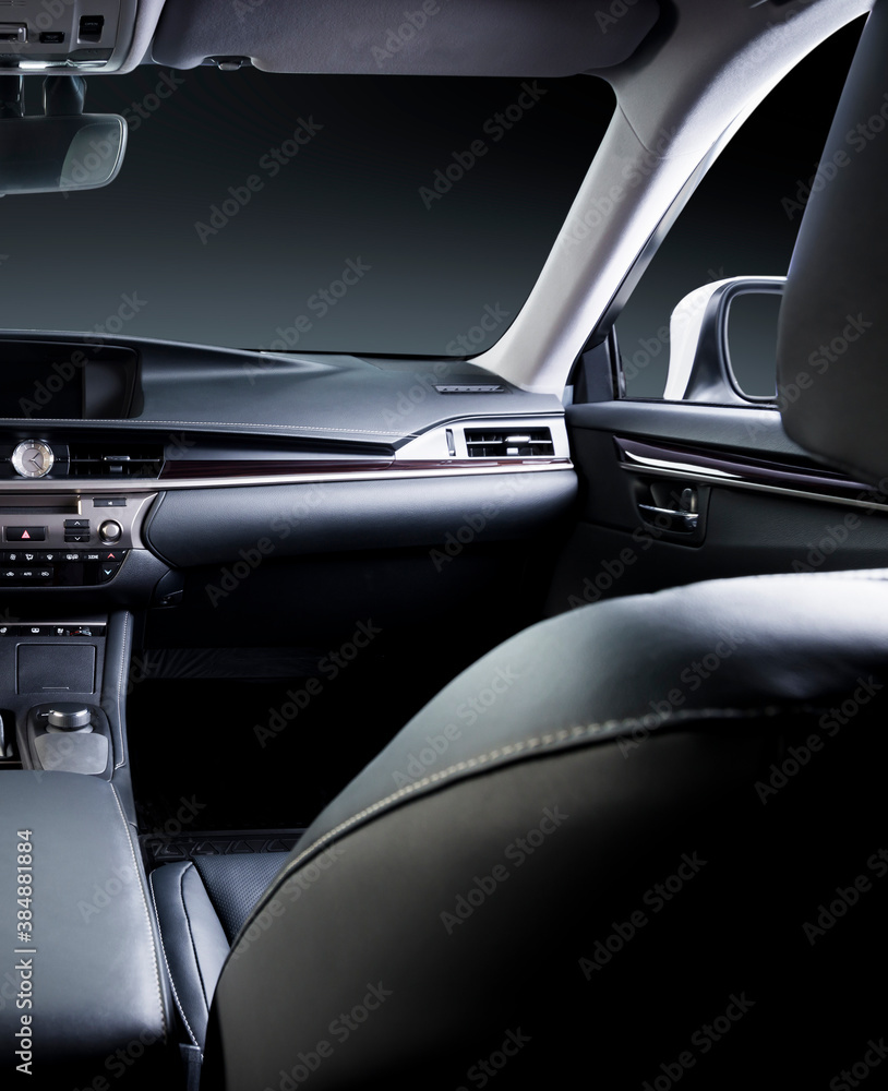 Dark luxury car Interior - steering wheel, shift lever and dashboard. Car inside. Beige comfortable seats, steering wheel, dashboard, climate control, speedometer, display.