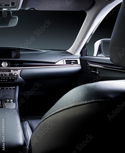 Dark luxury car Interior - steering wheel, shift lever and dashboard. Car inside. Beige comfortable seats, steering wheel, dashboard, climate control, speedometer, display. © gargantiopa