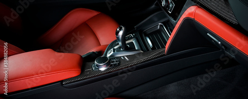 Modern luxury car Interior - steering wheel, shift lever and dashboard. Car interior luxury inside. Steering wheel, dashboard, speedometer, display. Red and black leather cockpit