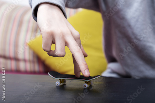 Boy is playing with his finger skateboard. Close up shot.