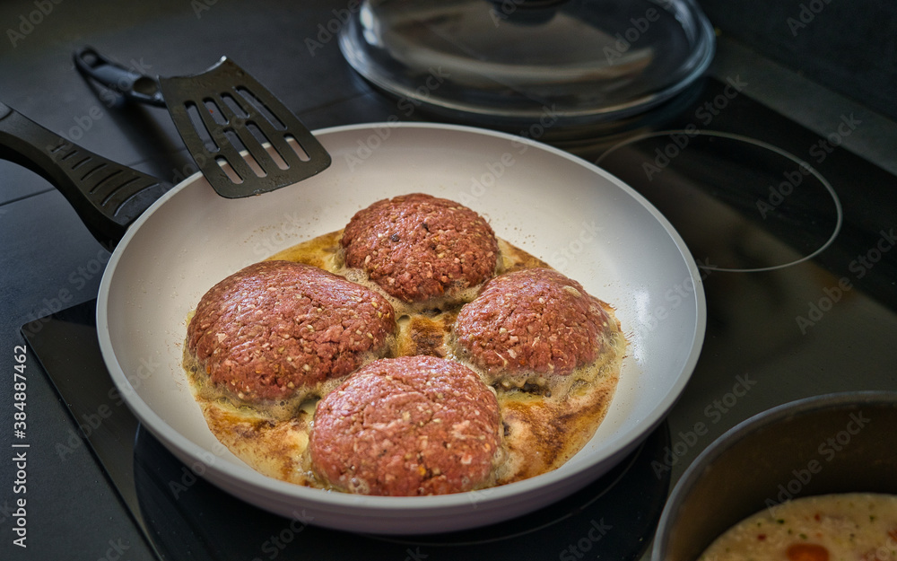 Frikadellen Gemüse Fleisch Paddys mit Kurkuma beim Anbraten in weißer Teflonpfanne mit Kokosöl, Produktbild Frikadellen Gemüse Fleisch Paddys mit Kurkuma beim Anbraten in weißer Teflonpfanne mit Kokosöl, Produktbild