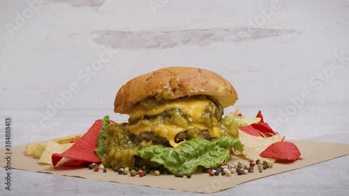 Green chile oozing out of a delicious, gourmet cheeseburger. The greasy, decadent hamburger is a classic American meal. Studio shot of a high quality burger made from ground beef or plant based meat. 