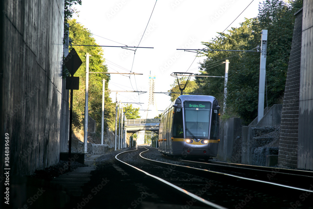 Dublin, Ireland - September 27, 2020: Beautiful view of Luas tram entering Balally Luas stop in the autumnal morning Dublin, Ireland - September 27, 2020: Beautiful view of Luas tram entering Balally Luas stop in the autumnal morning
