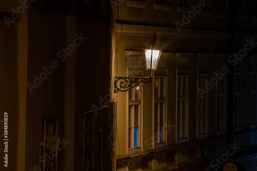 street lamp and sidewalk with cobblestones and light reflections after the rain in the center of the old town of Prague in the Czech Republic