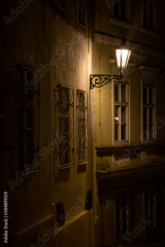 street lamp and sidewalk with cobblestones and light reflections after the rain in the center of the old town of Prague in the Czech Republic