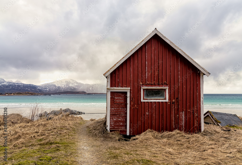 Red hut next to a path leading to Ramberg beach, Lofoten, Norway