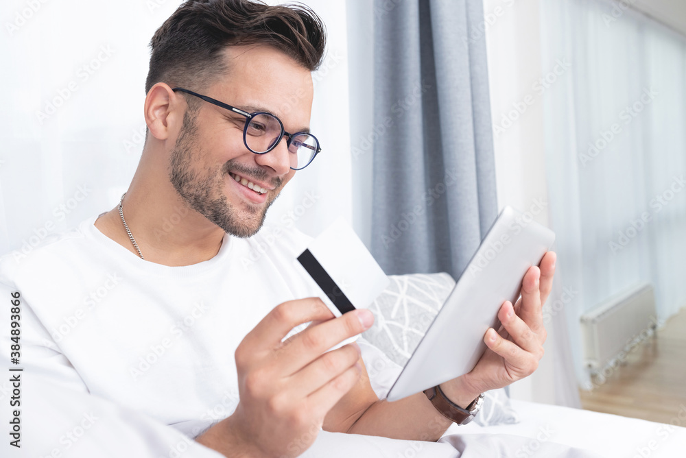 Happy man with digital tablet and credit card at home Happy man with digital tablet and credit card at home